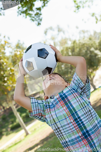 Image of Cute Young Boy Playing with Soccer Ball Outdoors in the Park.