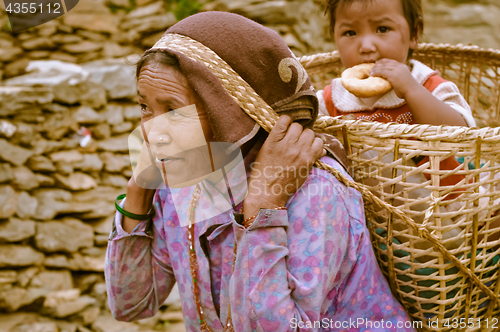 Image of Woman with child in basket in Nepal