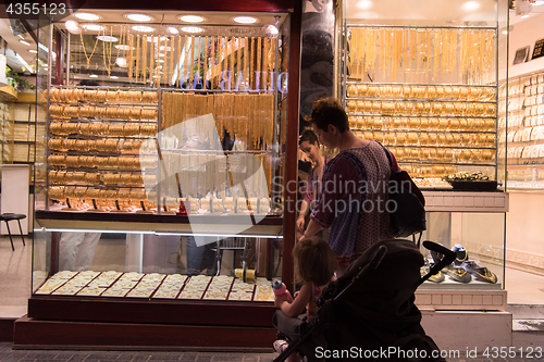 Image of mother with  little girl in a stroller in front of  jewelry shop