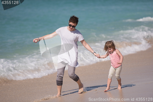Image of mother and daughter running on the beach