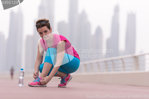 Image of woman tying shoelaces on sneakers