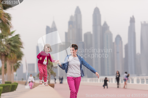 Image of mother and cute little girl on the promenade