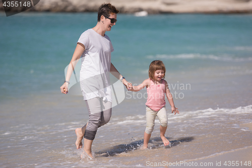 Image of mother and daughter running on the beach