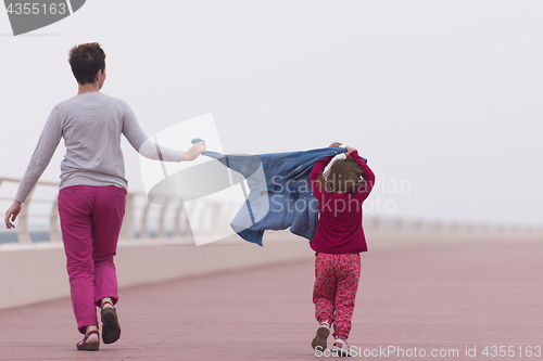 Image of mother and cute little girl on the promenade by the sea