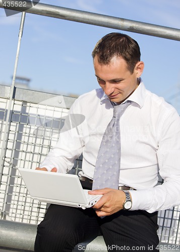 Image of handsome businessman with laptop computer