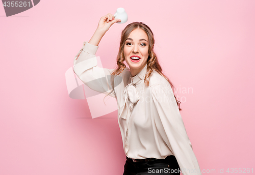 Image of The serious frustrated young beautiful business woman on pink background