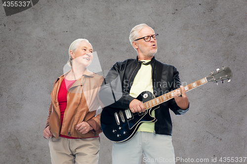 Image of happy senior couple with electric guitar