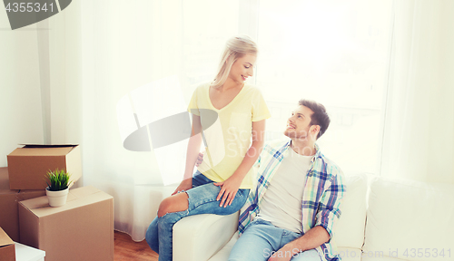 Image of happy couple with big cardboard boxes at new home