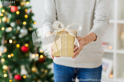 Image of close up of man with christmas gift at home