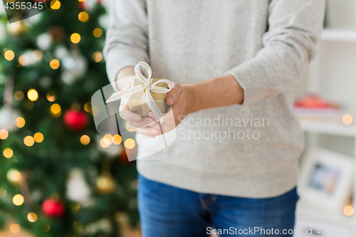 Image of close up of man with christmas gift at home