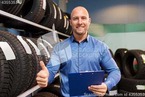 Image of auto business owner and wheel tires at car service