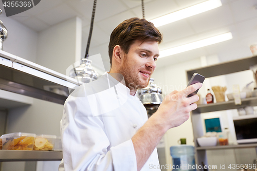 Image of chef cook with smartphone at restaurant kitchen