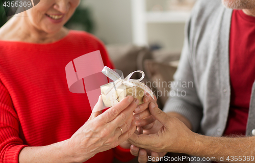 Image of close up of senior couple with christmas gift