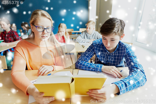 Image of students reading book at school lesson