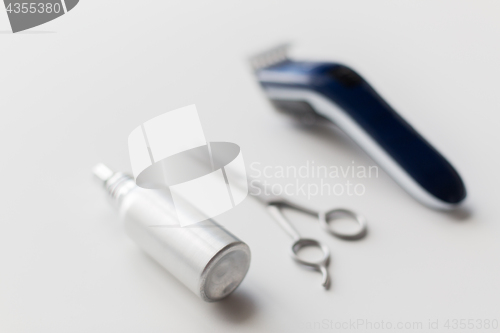 Image of styling hair spray, trimmer and scissors