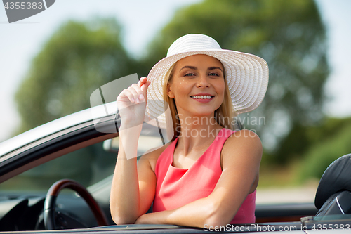 Image of happy young woman in convertible car