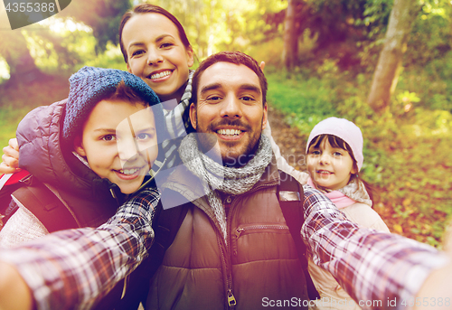 Image of family with backpacks taking selfie and hiking