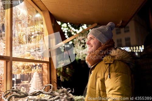 Image of happy man looking at christmas market shop window