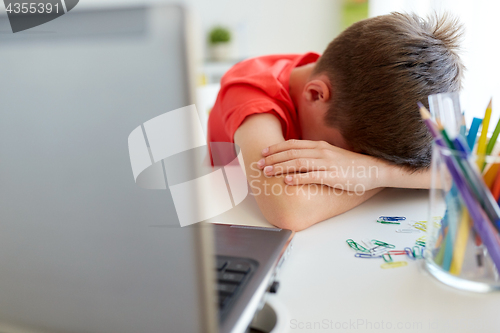 Image of tired or sad student boy with laptop at home