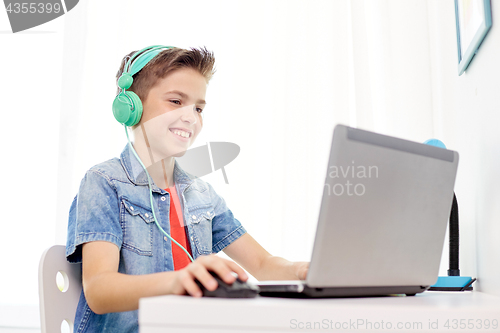 Image of boy in headphones playing video game on laptop