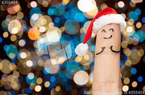 Image of finger with smiley in santa hat at christmas