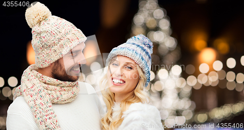 Image of happy couple hugging over christmas lights