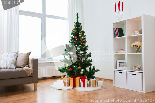 Image of artificial christmas tree and presents at home