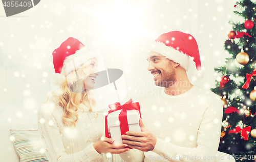 Image of happy couple at home with christmas gift box