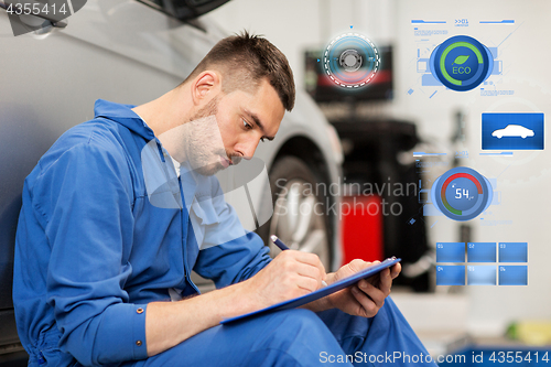 Image of auto mechanic man with clipboard at car workshop