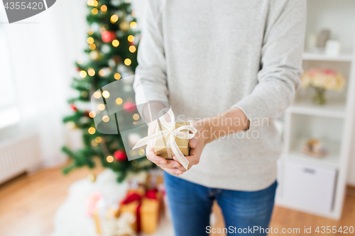 Image of close up of man with christmas gift at home