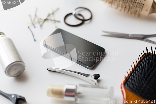 Image of smartphone, scissors, brushes and other hair tools