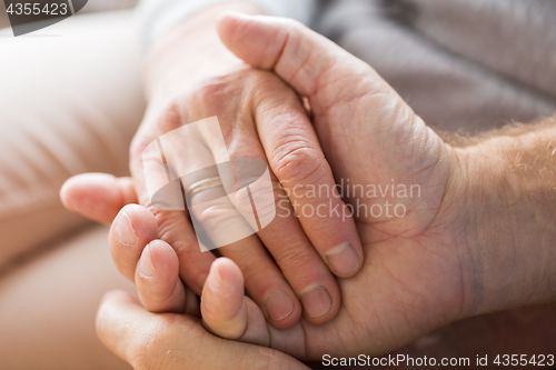 Image of close up of senior couple holding hands