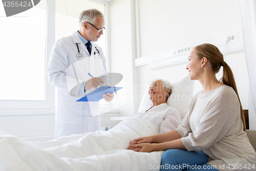 Image of senior woman and doctor with clipboard at hospital