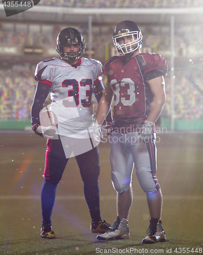 Image of Two American football players standing  on the field