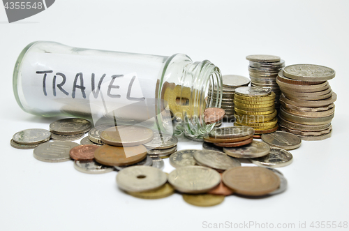 Image of Travel lable in a glass jar with coins spilling out