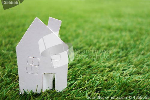 Image of Paper house against on green grass