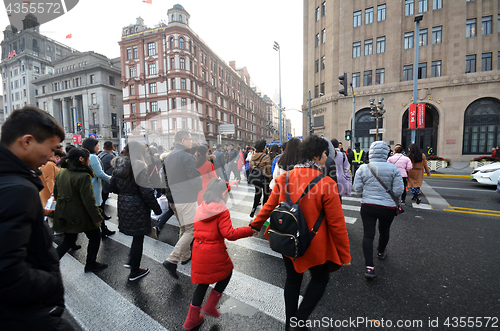 Image of Commuters in a busy crosswalk at the Bund in Shanghai, China