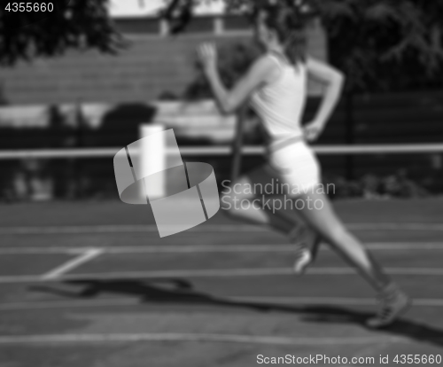 Image of Black and white blurred view of running girl at stadium