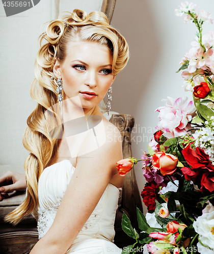 Image of beauty young blond woman bride alone in luxury vintage interior with a lot of flowers 