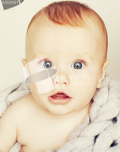 Image of little cute red head baby in scarf all over him close up isolate