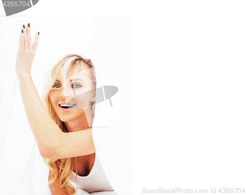 Image of young pretty blond woman in bed covered white sheets smiling che