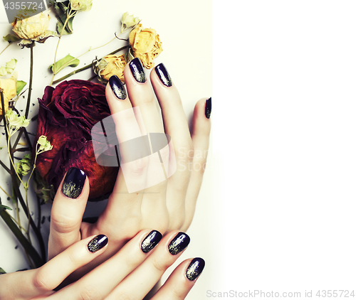 Image of close up picture of manicure nails with dry flower red rose