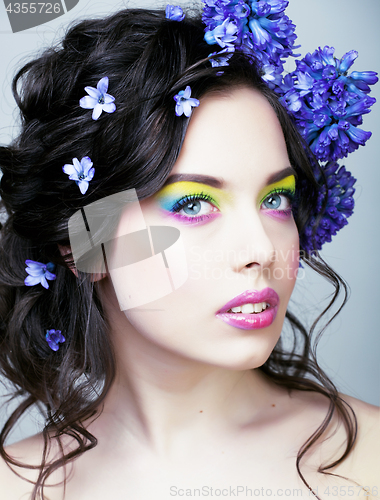 Image of Beauty young woman with flowers and make up close up, real sprin