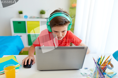 Image of boy in headphones playing video game on laptop