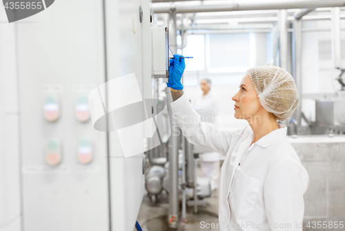 Image of woman programming computer at ice cream factory