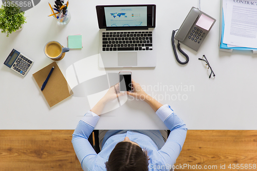 Image of businesswoman with laptop and smartphone at office