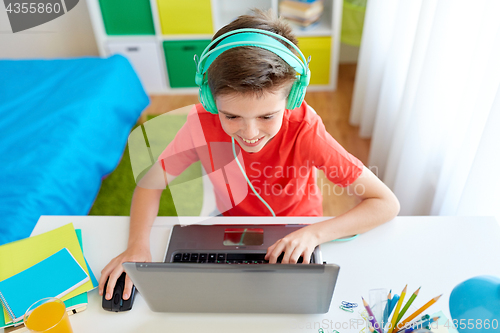 Image of boy in headphones playing video game on laptop