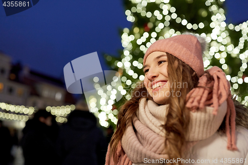 Image of happy young woman at christmas market in winter