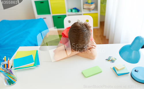 Image of tired or sad student boy with smartphone at home