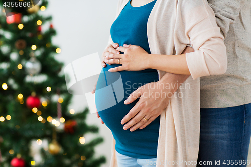 Image of man and pregnant woman home at christmas